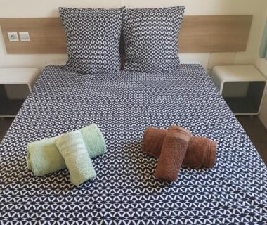 Chambre avec lit double oreillers et serviettes pliées dans Linge literie et toilette fournis