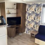 Intérieur mobil-home avec canapé et télévision dans Linge literie et toilette fournis