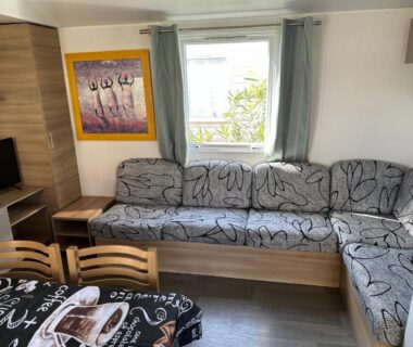Salon avec canapé d'angle et table au logement Linge literie et toilette fournis