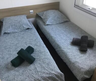 Chambre avec deux lits simples et serviettes dans le logement Linge literie et toilette fournis