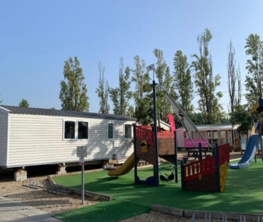 Aire de jeux avec toboggan et mobil-homes au camping Little John