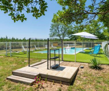 Piscine extérieure clôturée avec solarium et parasol au Lodge 2 du Domaine Des Landes