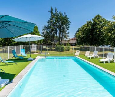 Piscine extérieure avec parasols et transats au Lodge 2 Domaine Des Landes