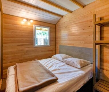 Chambre en bois avec lit double dans le Lodge 2 du Domaine Des Landes