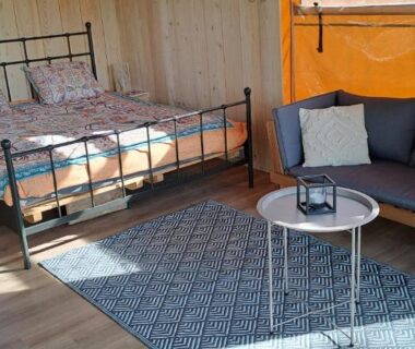 Intérieur de tente avec lit et coin salon du Lodge Safari tent