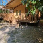 Terrasse en bois et tente lodge sous les arbres au Lodges & Nature 47