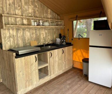 Intérieur kitchenette de lodge avec réfrigérateur et évier au Lodges & Nature 47