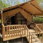 Terrasse en bois d'une tente lodge avec coin salon au Lodges & Nature 49
