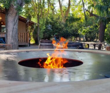 Terrasse autour d'un foyer circulaire avec flammes au Lodges & Nature - 49