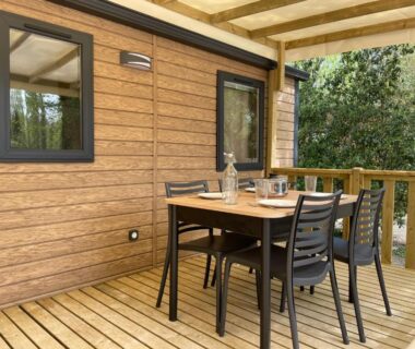 Terrasse en bois avec table et chaises à Lodges & Nature – 71