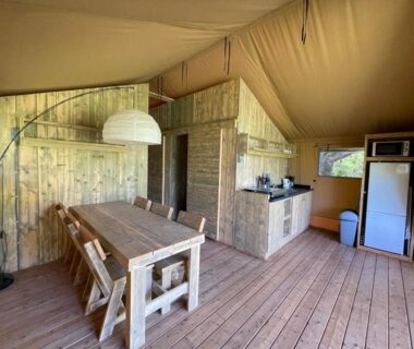 Intérieur de lodge avec coin repas et kitchenette aux Lodges du Bois Dodo