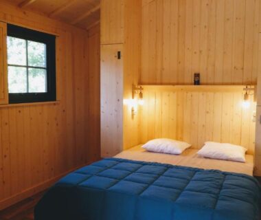 Intérieur en bois avec lit double dans les Lodges du Ushuaïa Villages Camping les 4 Saisons