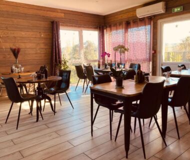 Salle à manger intérieure avec tables et chaises aux Lodges du Ushuaïa Villages Camping les 4 Saisons