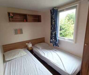 Chambre avec deux lits et fenêtre dans le Logement 3 chambres – Vue Lac Camping 4 étoiles Foix