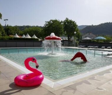 Piscine enfants avec fontaine et bouée flamant au Logement 3 chambres – Vue Lac Camping 4 étoiles Foix
