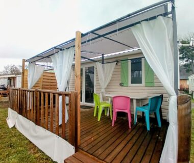 Terrasse couverte avec table et chaises colorées du Logement 3 chambres Vue Lac au Camping 4 étoiles Foix