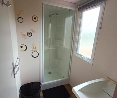 Salle d'eau avec douche vitrée et lavabo dans le Logement 3 chambres Vue Lac Camping 4 étoiles Foix