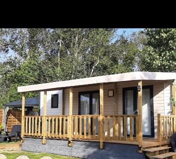 Mobil-home avec terrasse en bois et pelouse dans le Logement calme