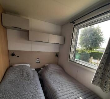 Chambre avec deux lits simples et fenêtre dans le Logement calme