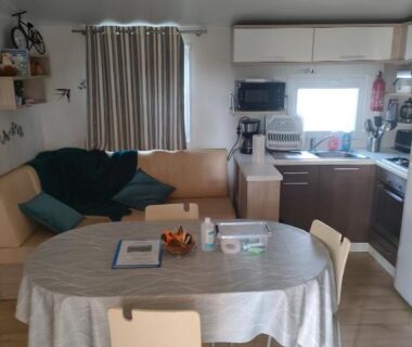Salon avec coin repas et kitchenette dans le mobil-home L'Orée du Bois