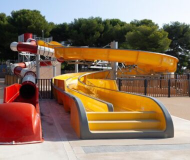Piscine avec toboggans jaunes et rouges au camping Lou Soleil 80