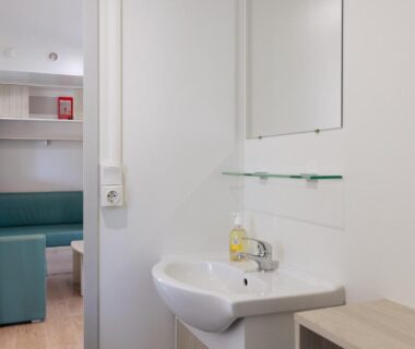 Salle d'eau avec lavabo et coin salon au Lou Soleil 80