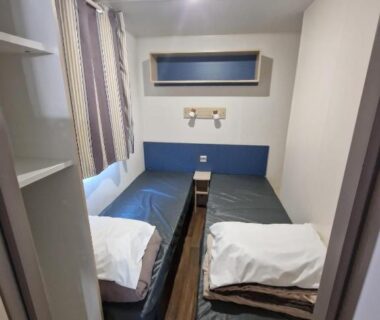 Chambre avec deux lits simples et fenêtre dans Loue mobil home 4-6 personnes Torreilles