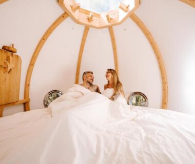 Intérieur d'une cabine ronde avec lit et couple dans le Lov'nid spa et sauna