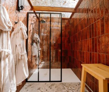 Salle de bain avec douche à l'italienne et peignoirs dans le Lov'nid spa et sauna