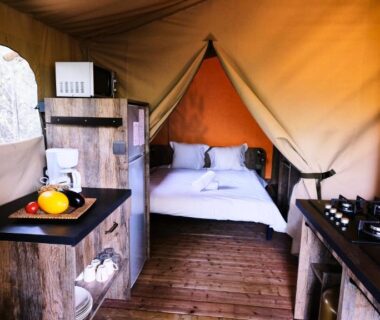 Intérieur de tente avec lit et kitchenette au Ludocamping