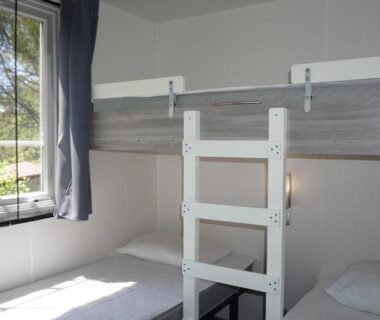 Chambre avec lits superposés et fenêtre dans le Luxe chalet voor 5 personnes op Camping Leï Suves – JoyCasa