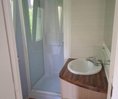 Salle de bain avec cabine douche et lavabo dans le mobil-home Lya