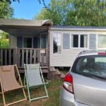 Mobil-home avec terrasse et chaises longues au camping Lya