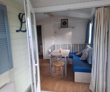 Terrasse donnant sur séjour avec banquette bleue au Lya