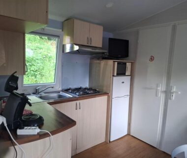 Cuisine équipée avec réfrigérateur et plaque de cuisson dans le mobil-home Lya
