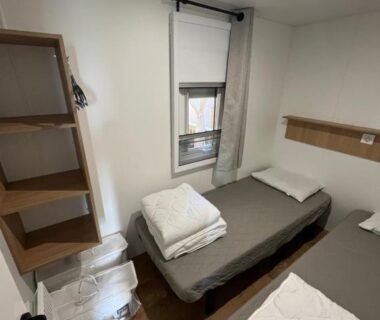 Chambre avec deux lits simples étagère et fenêtre au MA105 Le Mazet