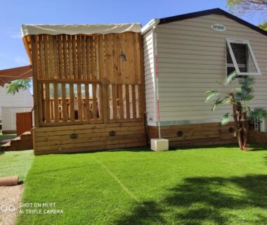 Terrasse en bois et pelouse devant mobil home au camping MAR ESTANG