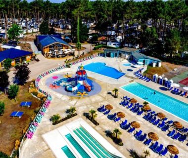 Espace aquatique avec toboggans, bassins et chaises longues du MH 142B Camping Les dunes de Contis