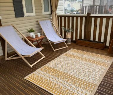 Terrasse couverte avec chaises longues tapis et table du MH 142B Camping Les dunes de Contis
