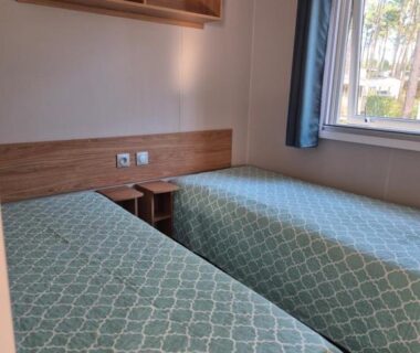 Chambre avec deux lits et fenêtre dans le MH 201 AGREABLE