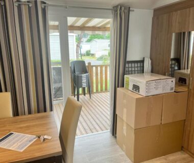 Séjour avec table chaises cartons et terrasse du MH 305 3 chambres et 1 salle de bain
