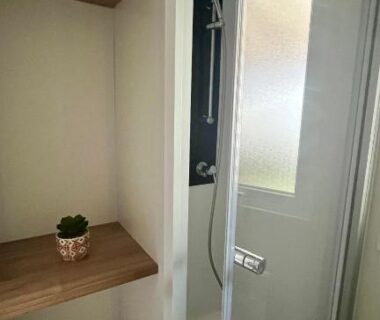 Salle de bain avec cabine de douche et étagères dans le MH 385 Les Dunes de Contis
