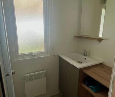Salle de bain avec lavabo fenêtre et miroir dans le MH 385 Les Dunes de Contis