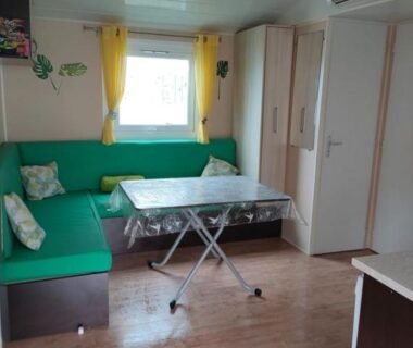 Intérieur séjour avec banquette et table dans le MH 387 3 chambres 1 salle de bain du camping 4 étoiles