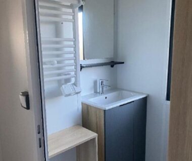 Salle d'eau avec lavabo miroir et sèche-serviettes dans le MH 3CH à l'océan Landais chez Claiclé
