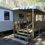 Terrasse en bois ombragée avec mobilier et escalier du mobil-home MH 414 SAMBA 3chambres et 1salle de bain