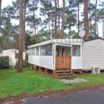Dans le camping sous pins mobil-home avec véranda MH 468 LUMINOSA
