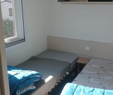 Chambre avec deux lits et fenêtre dans le MH 475 ELEGANZIA 2CH ET 1sdb