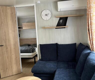 Salon banquette bleue table ronde du MH 479 3 chambres et 2 salles de bain dans camping 4 étoiles