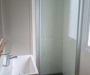 Salle de bain avec cabine de douche vitrée et lavabo dans le MH 480 2ch 2sdb 40m2